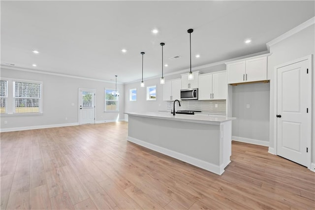 313 Foxglove Way, Mcdonough, GA 30253 - kitchen featuring light countertops, white cabinets, crown molding, and stainless steel microwave