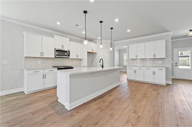 313 Foxglove Way, Mcdonough, GA 30253 - kitchen featuring crown molding, visible vents, stainless steel microwave, light countertops, and decorative backsplash