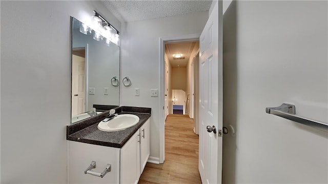 bathroom with vanity, hardwood / wood-style floors, and a textured ceiling