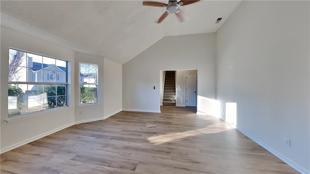 interior space with lofted ceiling, a textured ceiling, ceiling fan, and light hardwood / wood-style flooring