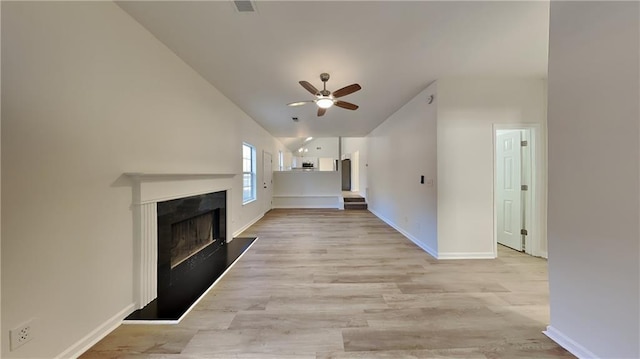 unfurnished living room featuring lofted ceiling, ceiling fan, and light hardwood / wood-style flooring