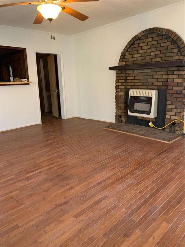 unfurnished living room with baseboards, heating unit, wood finished floors, and a ceiling fan