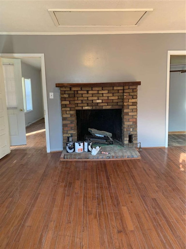 details with a brick fireplace, wood finished floors, baseboards, and ornamental molding