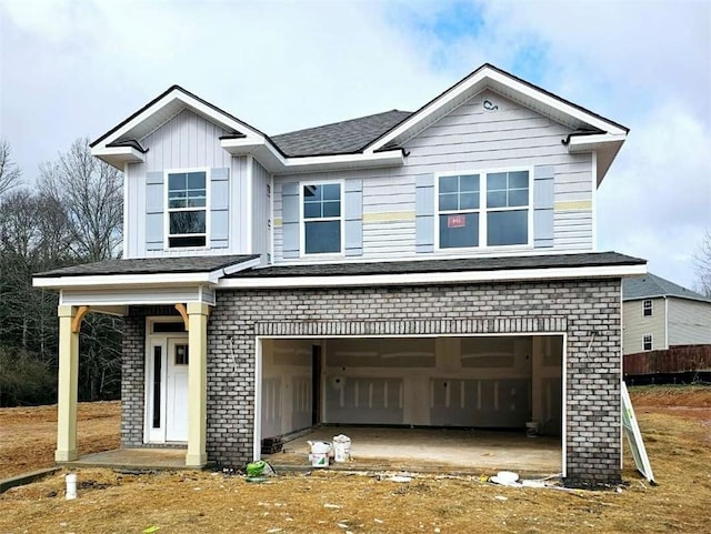 view of front of home featuring a garage, board and batten siding, and brick siding