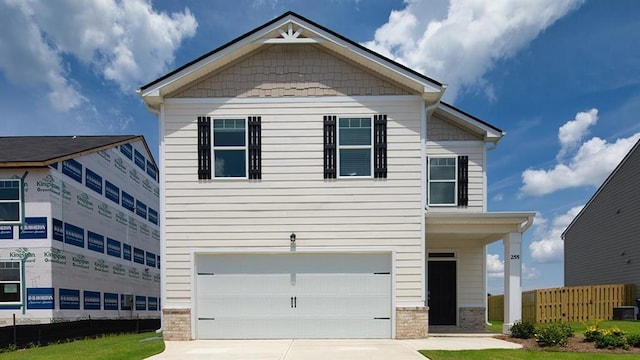 craftsman-style home featuring an attached garage, fence, concrete driveway, and brick siding