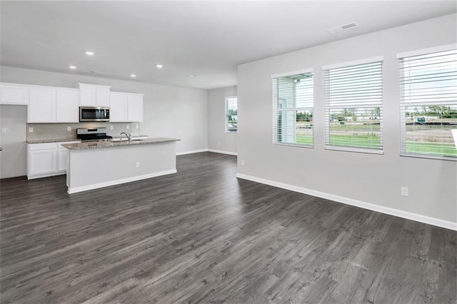 kitchen featuring appliances with stainless steel finishes, visible vents, dark wood-type flooring, and white cabinetry
