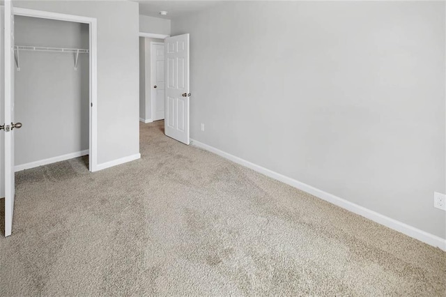 unfurnished bedroom featuring a closet, baseboards, and carpet flooring