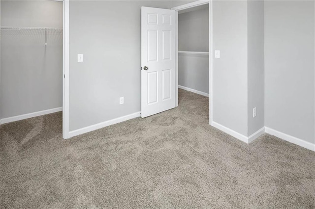unfurnished bedroom with carpet, a closet, and baseboards