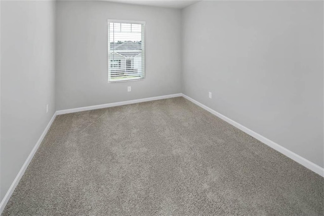 carpeted empty room with baseboards