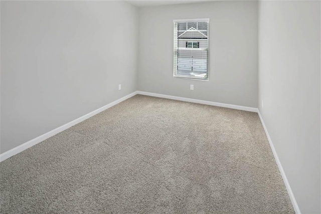 unfurnished room with carpet and baseboards
