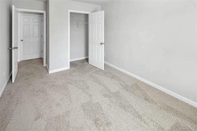 unfurnished bedroom with carpet floors, a closet, and baseboards