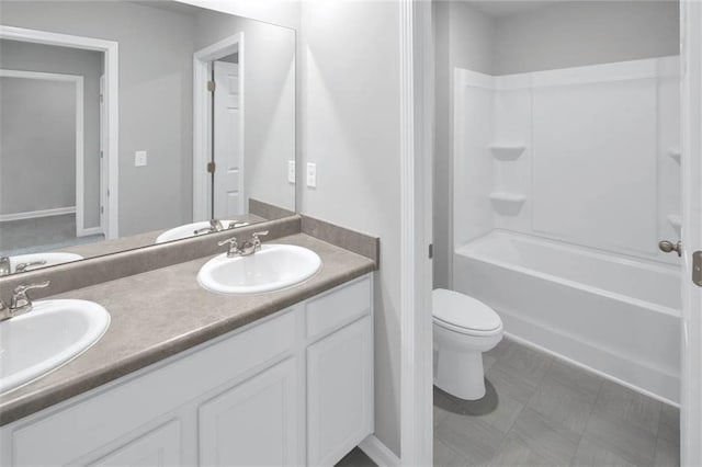bathroom with toilet, double vanity, tub / shower combination, and a sink