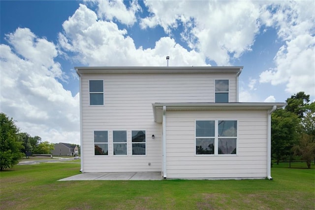 back of house with a patio and a lawn