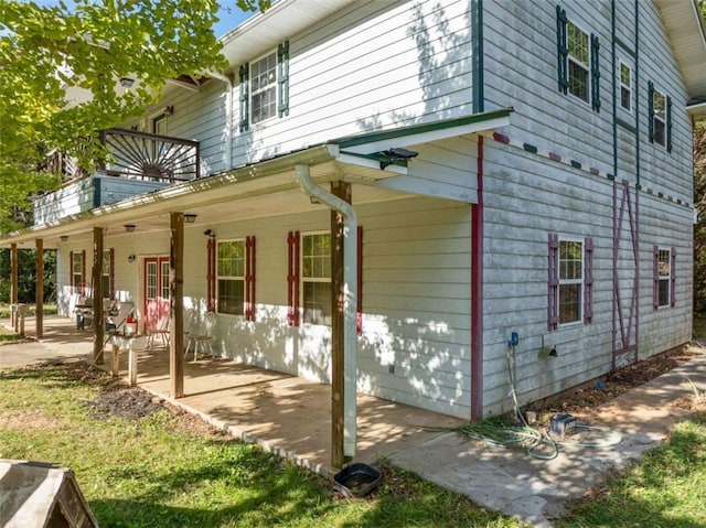 view of property exterior with covered porch and a patio area