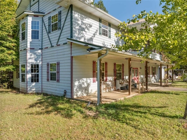 rear view of house with a yard and a patio