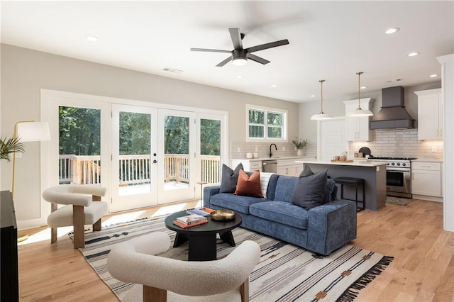 living room featuring french doors, light hardwood / wood-style floors, and ceiling fan