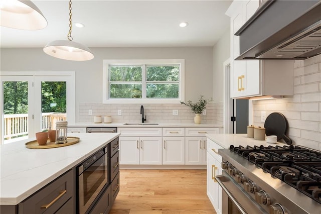 kitchen with high end stainless steel range oven, sink, white cabinetry, extractor fan, and built in microwave