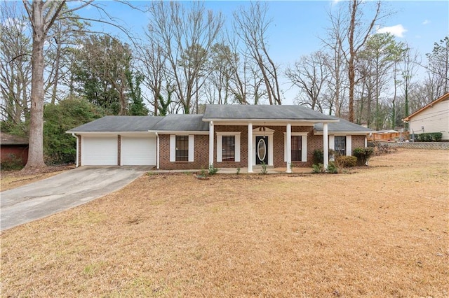 view of front of property featuring a garage, covered porch, and a front yard