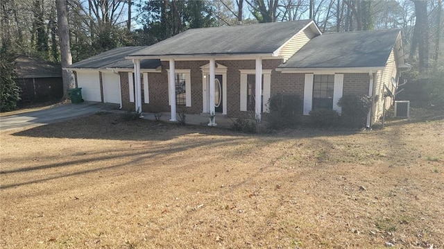 view of front of house featuring a porch, a garage, central AC unit, and a front yard