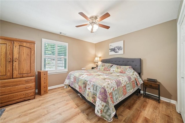 bedroom with baseboards, light wood finished floors, and a ceiling fan