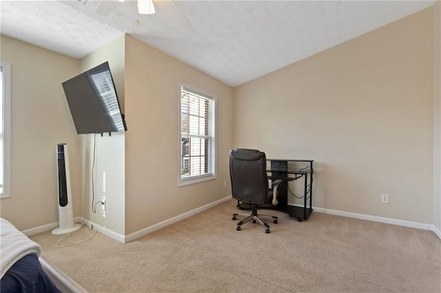 carpeted home office with ceiling fan and a textured ceiling