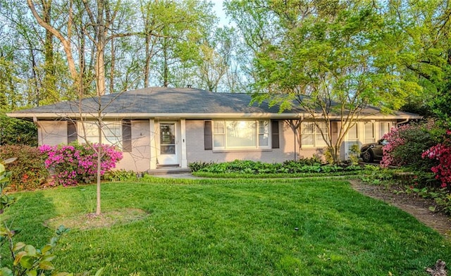 ranch-style home with brick siding and a front lawn