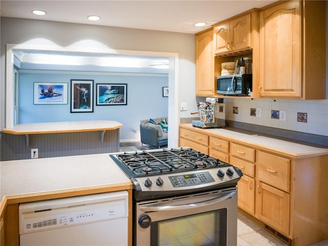 kitchen with light brown cabinets, visible vents, light countertops, appliances with stainless steel finishes, and decorative backsplash