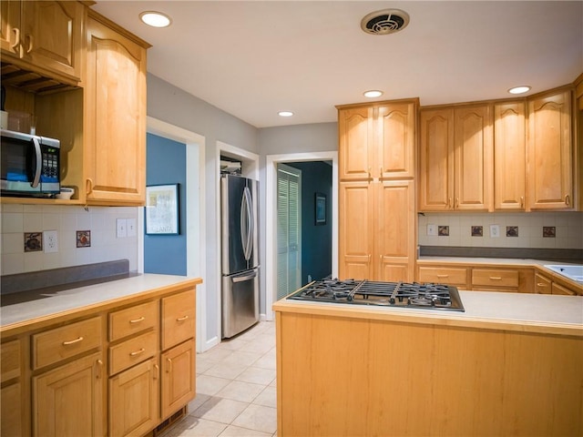 kitchen featuring recessed lighting, light countertops, decorative backsplash, appliances with stainless steel finishes, and light tile patterned flooring