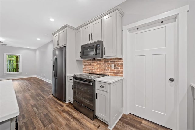 kitchen with appliances with stainless steel finishes, light countertops, tasteful backsplash, dark wood finished floors, and open floor plan