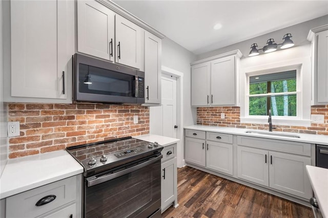 kitchen featuring range with electric stovetop, stainless steel microwave, a sink, and tasteful backsplash