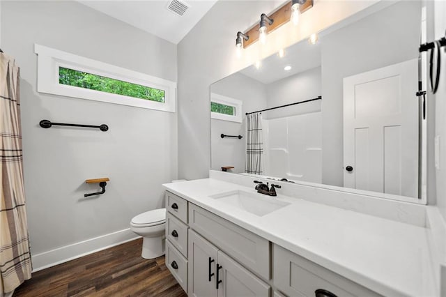 bathroom featuring toilet, wood finished floors, baseboards, vanity, and curtained shower