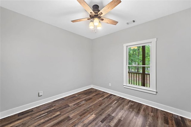 empty room featuring baseboards, dark wood finished floors, and ceiling fan