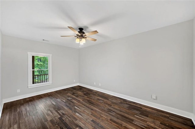 empty room featuring baseboards, dark wood-style flooring, and a ceiling fan