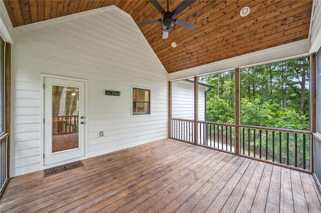 unfurnished sunroom with wooden ceiling, lofted ceiling, a ceiling fan, a deck, and wood-type flooring