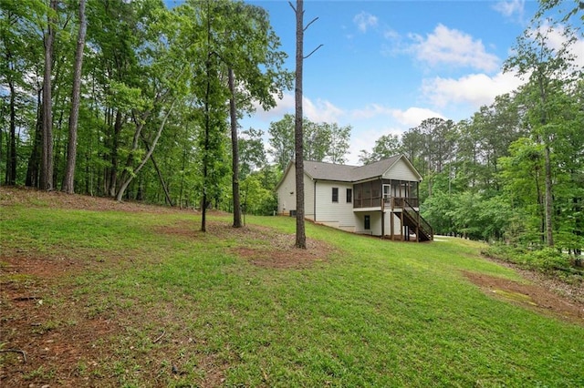 view of grassy yard with a sunroom and stairs