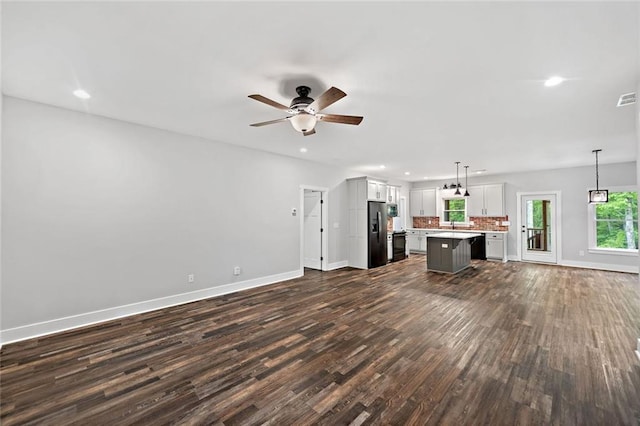 unfurnished living room with baseboards, dark wood-type flooring, a ceiling fan, and recessed lighting