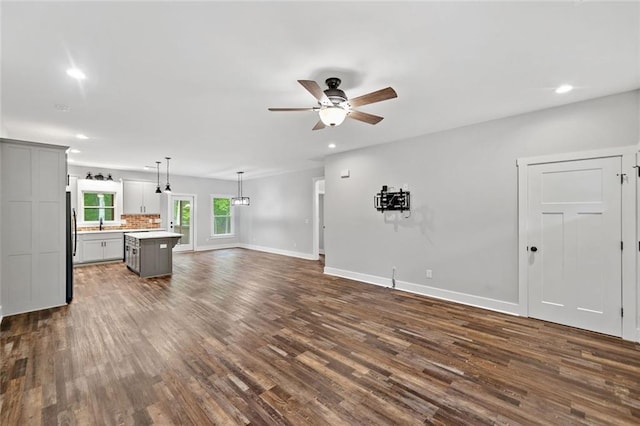 unfurnished living room featuring recessed lighting, dark wood-style floors, a ceiling fan, and baseboards