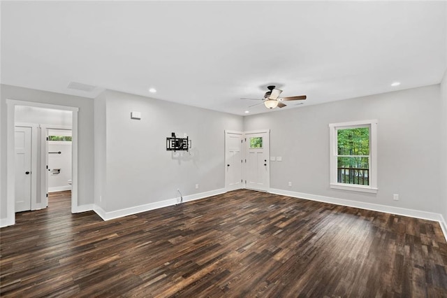 unfurnished living room with healthy amount of natural light, a ceiling fan, dark wood-type flooring, baseboards, and recessed lighting