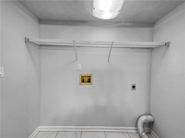 washroom featuring light tile patterned floors, a textured ceiling, hookup for a washing machine, and hookup for an electric dryer