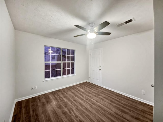 spare room featuring a textured ceiling, ceiling fan, and dark hardwood / wood-style floors