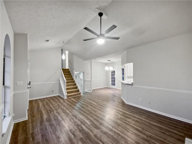 unfurnished living room with ceiling fan, dark hardwood / wood-style flooring, vaulted ceiling, and a textured ceiling