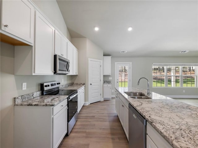 kitchen featuring white cabinets, visible vents, stainless steel appliances, and a sink