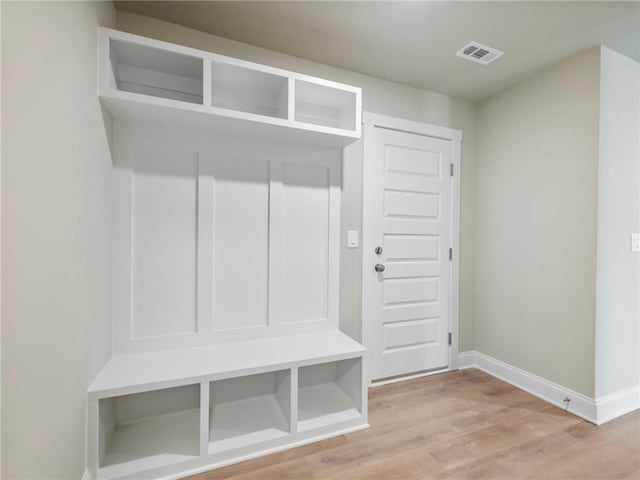 mudroom featuring light wood finished floors, visible vents, and baseboards