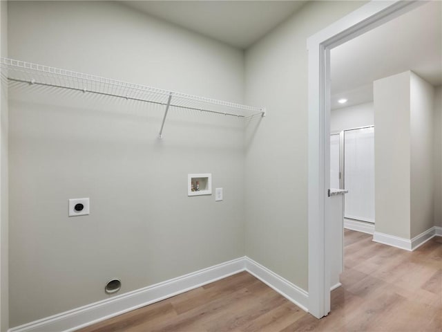 washroom with hookup for a washing machine, hookup for an electric dryer, laundry area, baseboards, and light wood finished floors