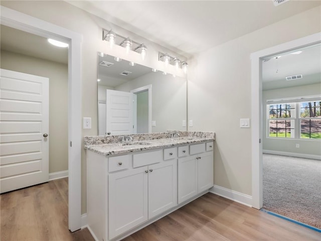 bathroom with visible vents, a sink, baseboards, and double vanity