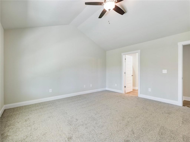 spare room with lofted ceiling, ceiling fan, baseboards, and light colored carpet