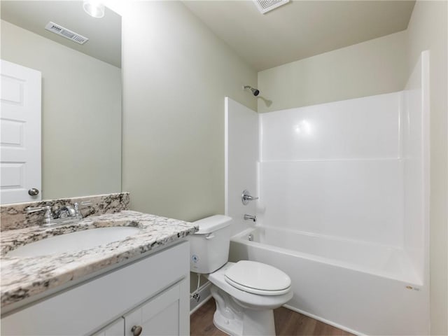 bathroom with bathing tub / shower combination, visible vents, toilet, vanity, and wood finished floors