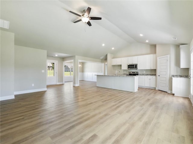 kitchen featuring light wood-style flooring, a center island with sink, appliances with stainless steel finishes, and open floor plan