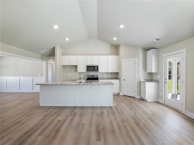 kitchen featuring light stone countertops, visible vents, stainless steel appliances, and a sink