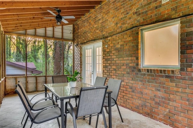 unfurnished sunroom with ceiling fan and vaulted ceiling with beams